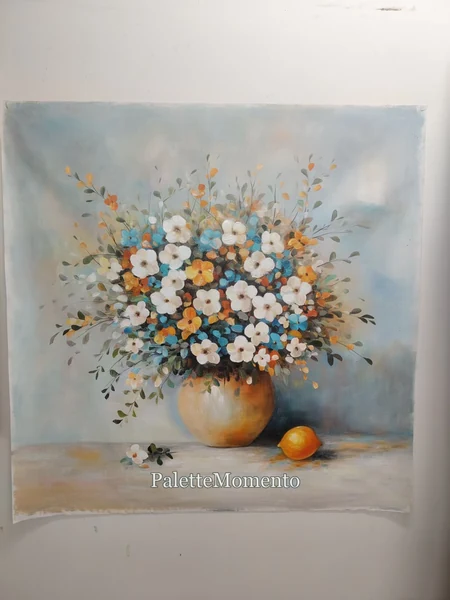 Floral still life with white blue and orange flowers in a vase beside a lemon