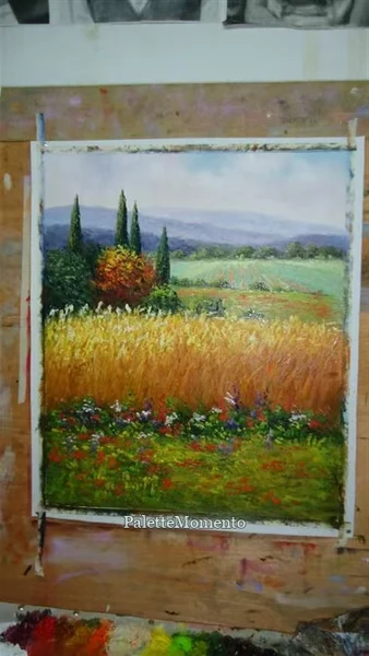 Field painting with cypress trees and wildflowers pinned to a studio board