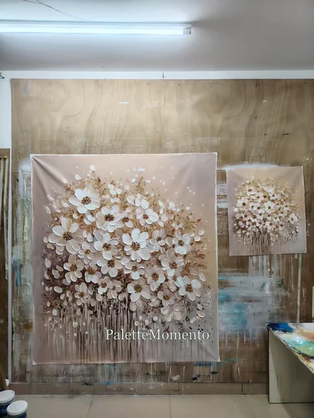 Two white floral canvases of different sizes photographed together on the studio wall