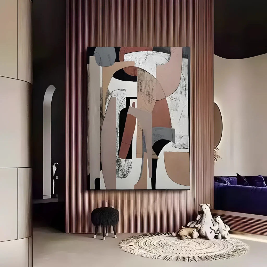 Blush pink, taupe, and black cubist collage wall art mounted on a ribbed wood slat wall above a round fringed jute rug, a shaggy black stool, and toy bears beside a navy blue daybed