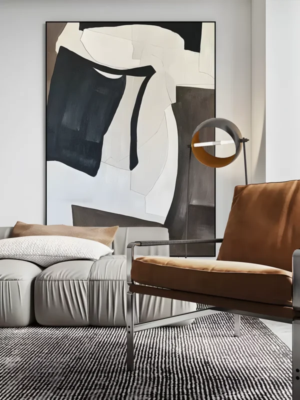 Black and cream bold gestural abstract painting displayed as framed wall art in a modern living room