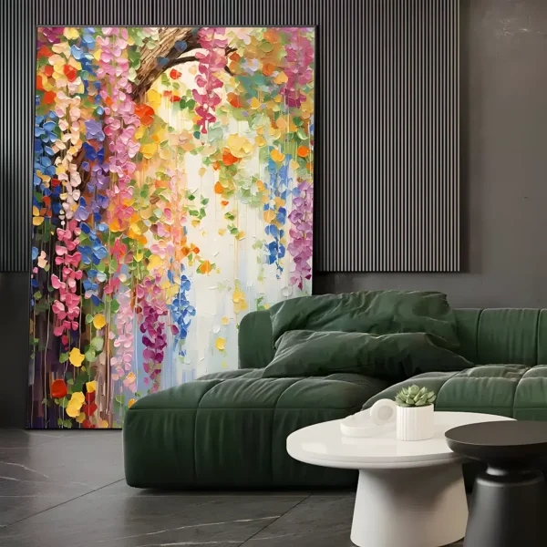 Tall wisteria canvas painting leaning on a black slatted panel wall behind a deep green sofa, its heavy impasto petal strands in pink, purple, blue, and yellow trailing down from an arching branch
