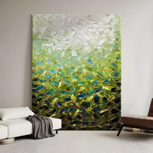 A large vertical textured abstract painting of white impasto fading down into green and blue palette-knife facets threaded with copper lines, displayed floor-standing beside a white sofa and a brown leather chair