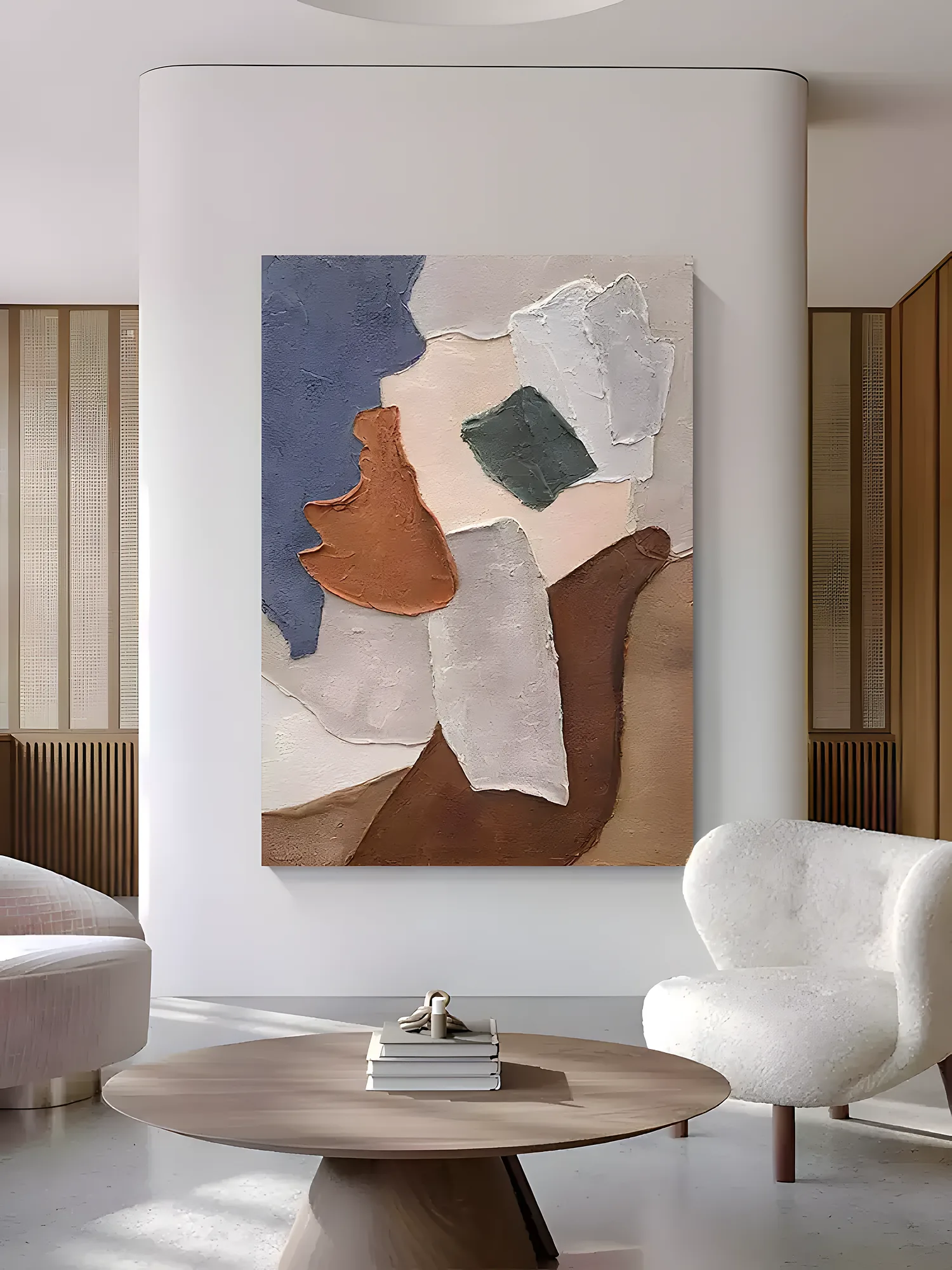 Torn-paper style canvas with a slate blue corner, terracotta swipe and chocolate brown palette-knife form, hung on a curved white wall above a round wood coffee table