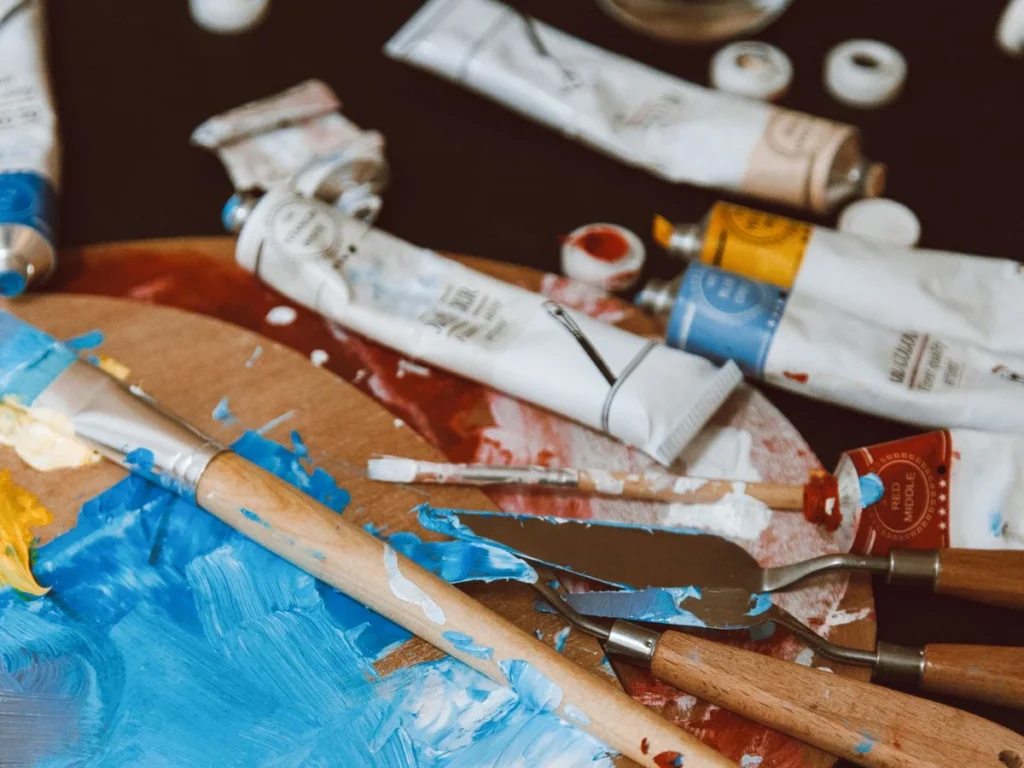 Oil paint tubes and palette knives on the studio worktable