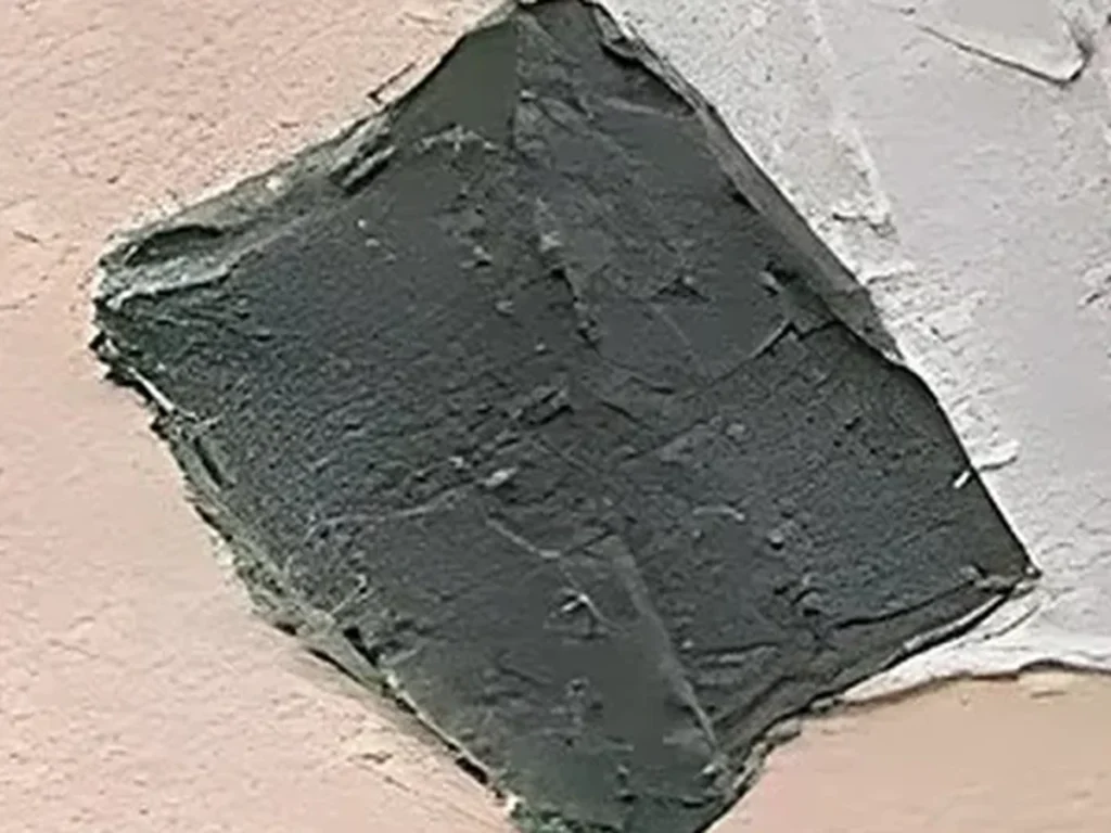 Close-up of torn raised plaster edges where the slate blue field meets rust and cream on wabi-sabi canvas WA09