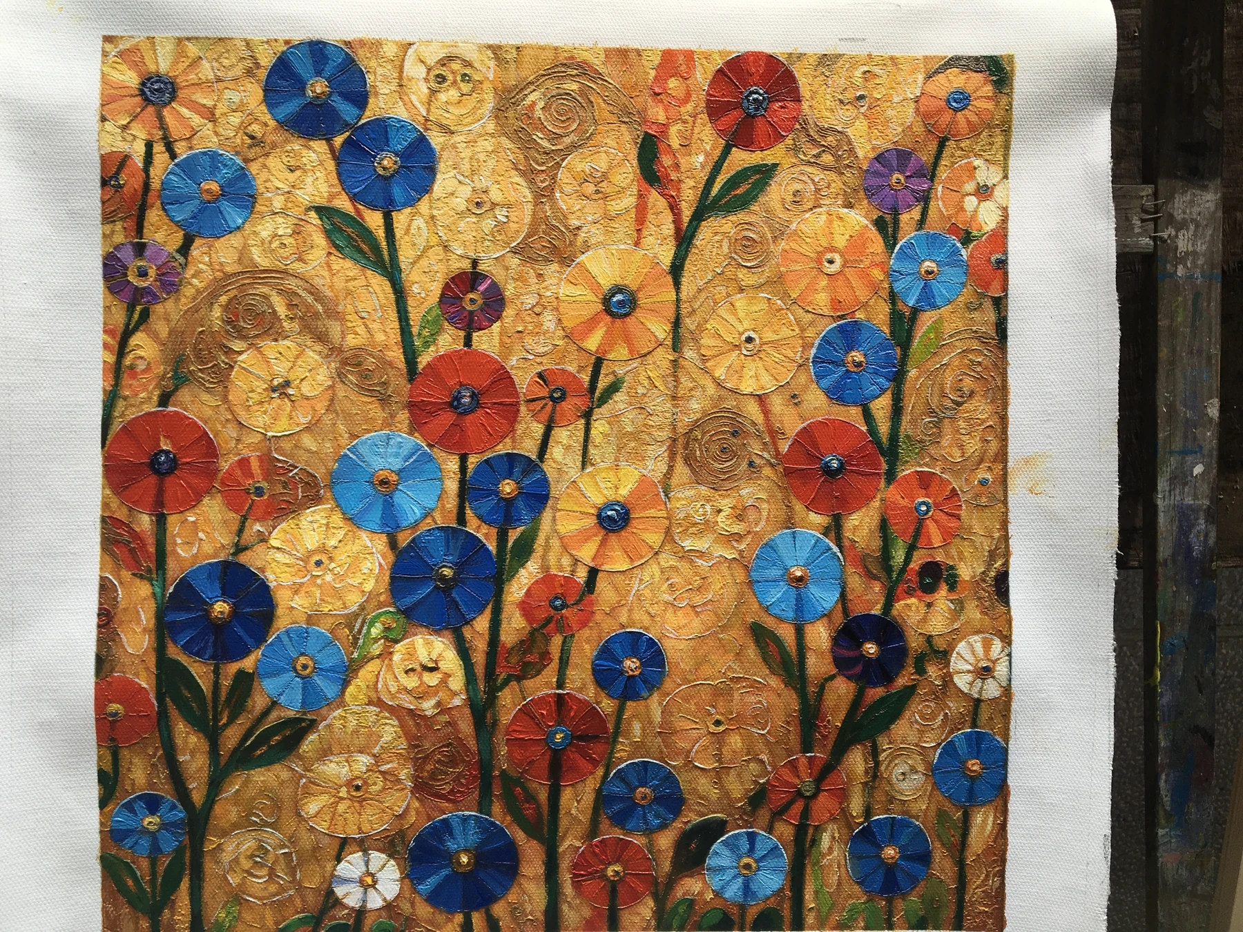 Finished floral painting with blue, red and yellow flowers and visible raised paint texture.