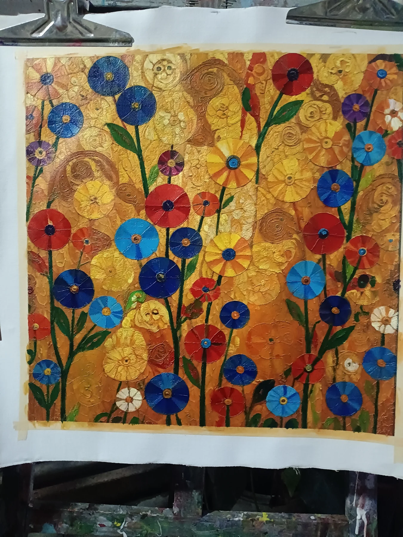 First painted layer of the floral artwork, with colorful flowers and green stems on a yellow-orange ground.