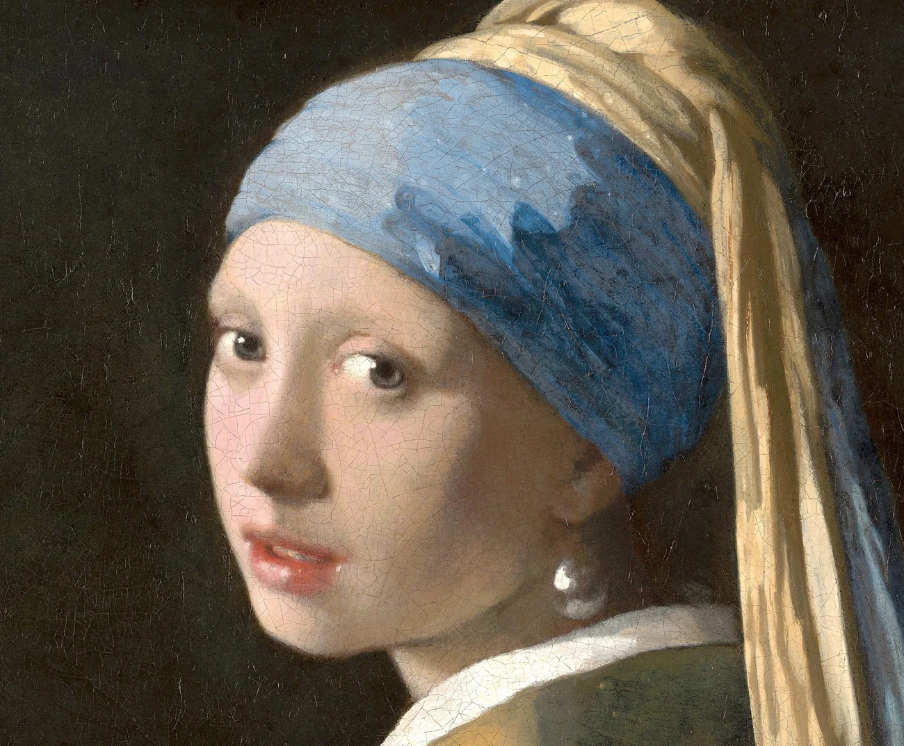 Detail of Girl with a Pearl Earring showing soft skin transitions, the blue headscarf, and the light-catching earring.