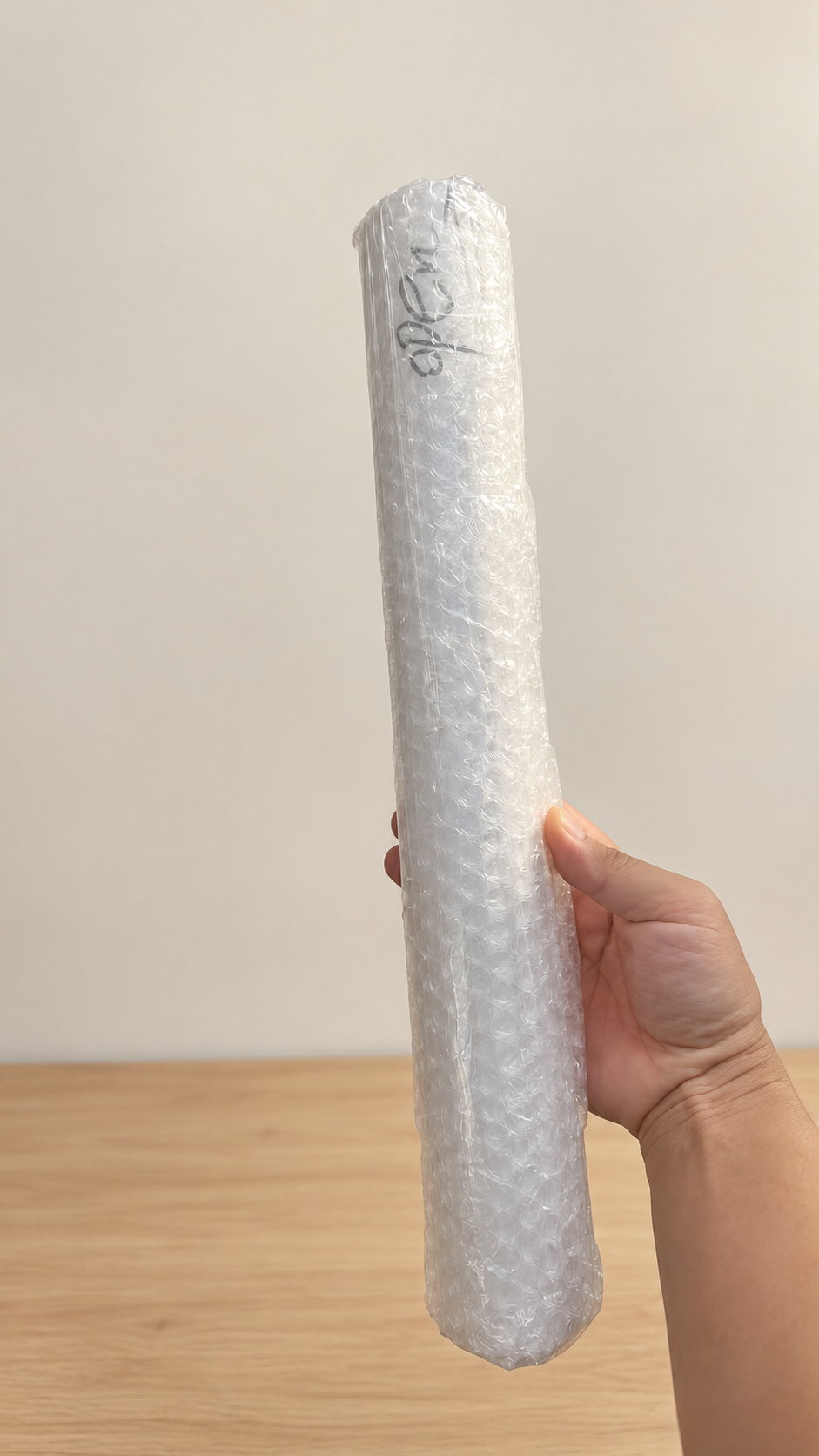 Bubble-wrapped rolled canvas held ready for transport.