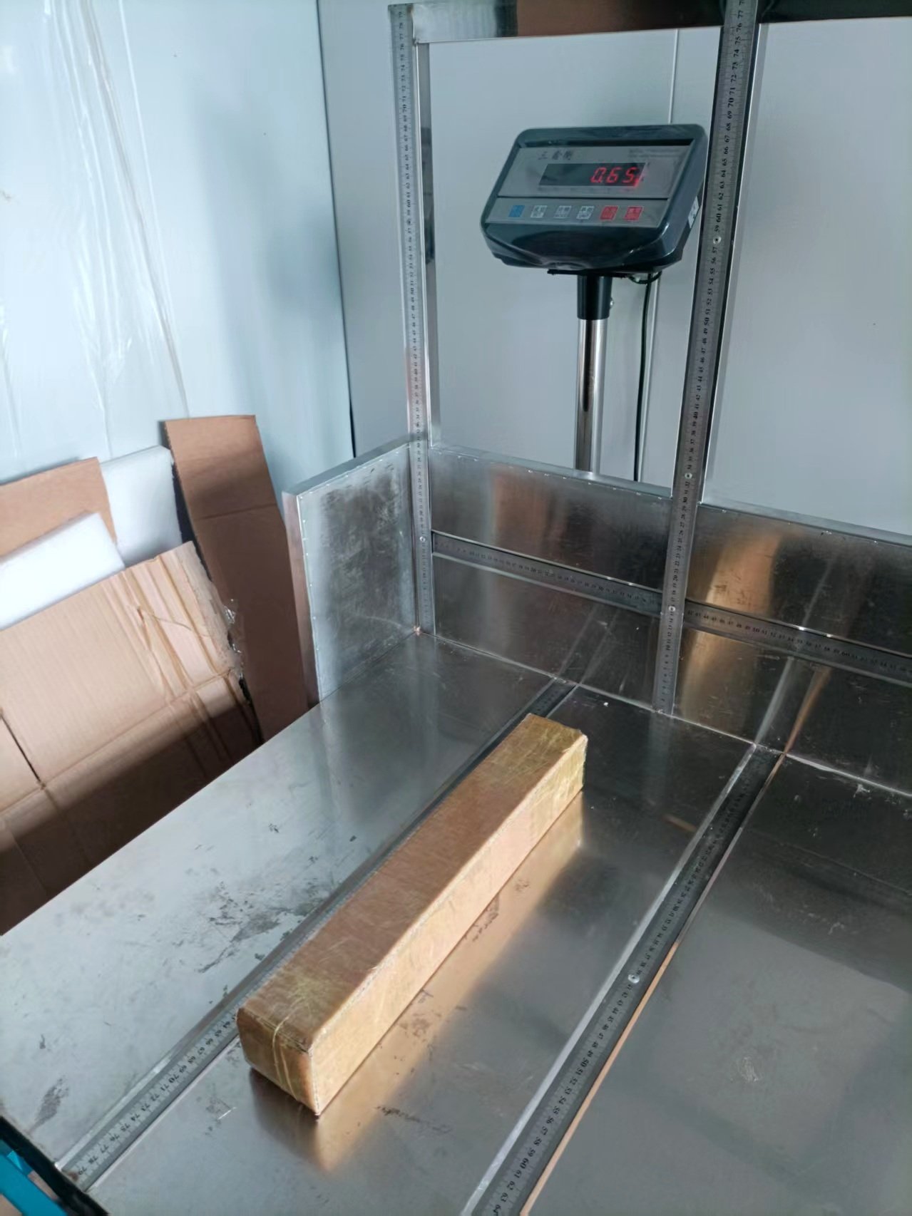 Digital scale checking the weight and dimensions of a boxed painting in the studio.