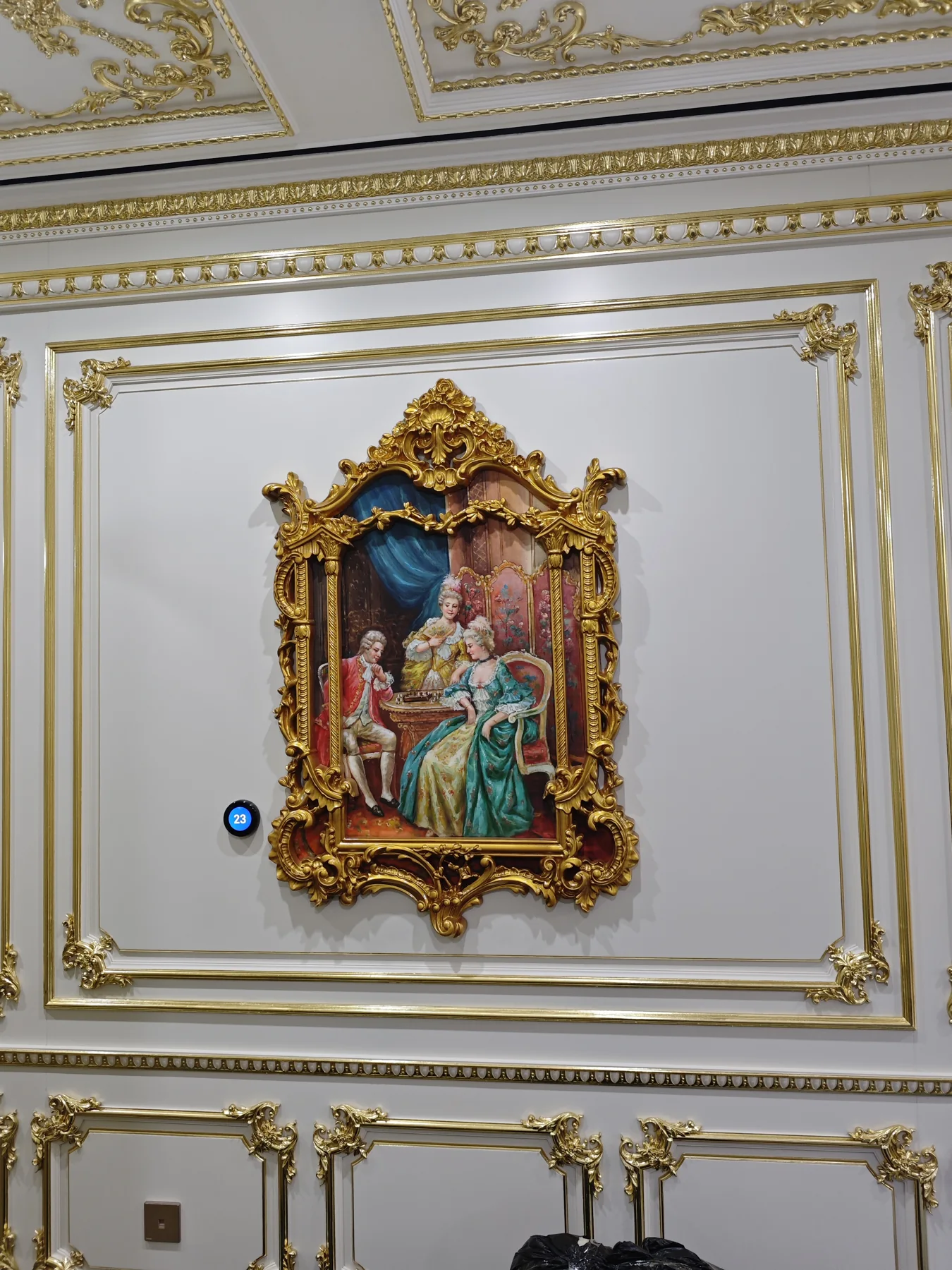 Figurative painting in an ornate gold frame on a decorative wall