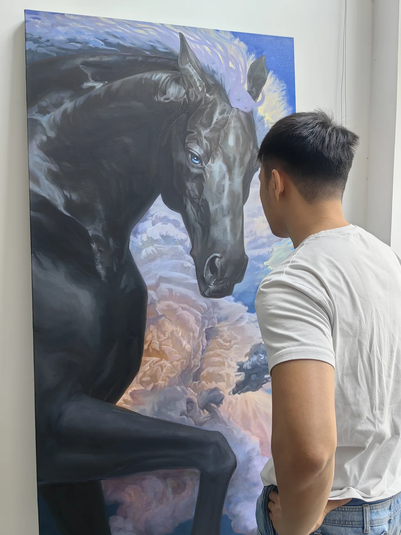 Large horse painting with a person standing close to inspect the canvas