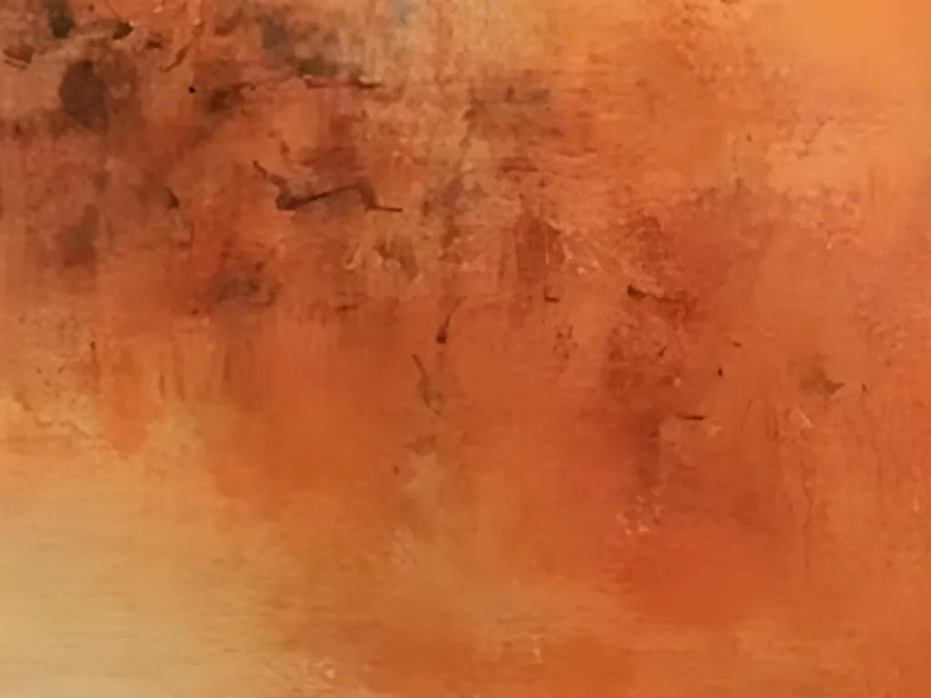 Close-up of the burnt orange and rust haze in abstract painting AA26, with tiny dark brown flecks, dry brushed scumbles and a soft golden glow fading in at the lower left