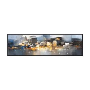 A large panoramic impressionist skyline painting of a waterfront city glowing gold, amber and cream between a charcoal and pale blue sky and dark streaked water dotted with small white sailboats, in a black frame